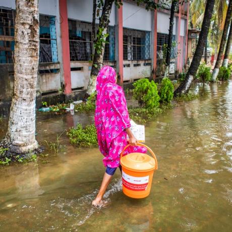 A woman collects essential relief items from an ActionAid distribution point in Noakhali Sadar District.